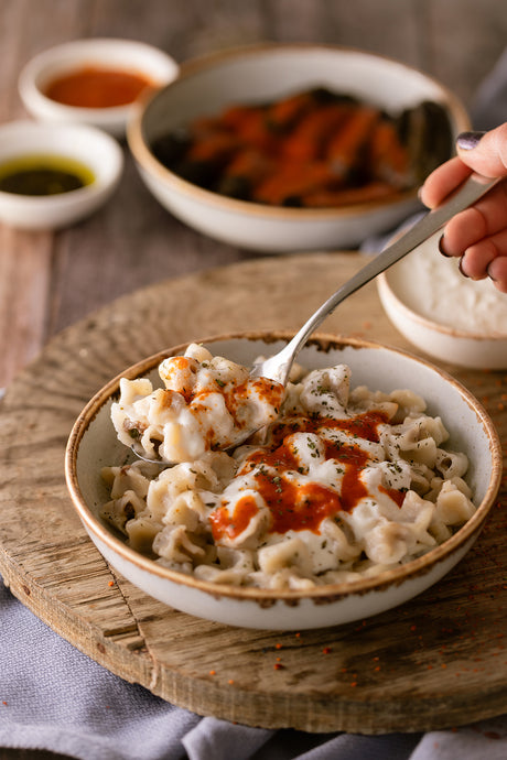 Anadolu Turkish Manti Dish in a plate, with special tomato paste and butter sauce. 